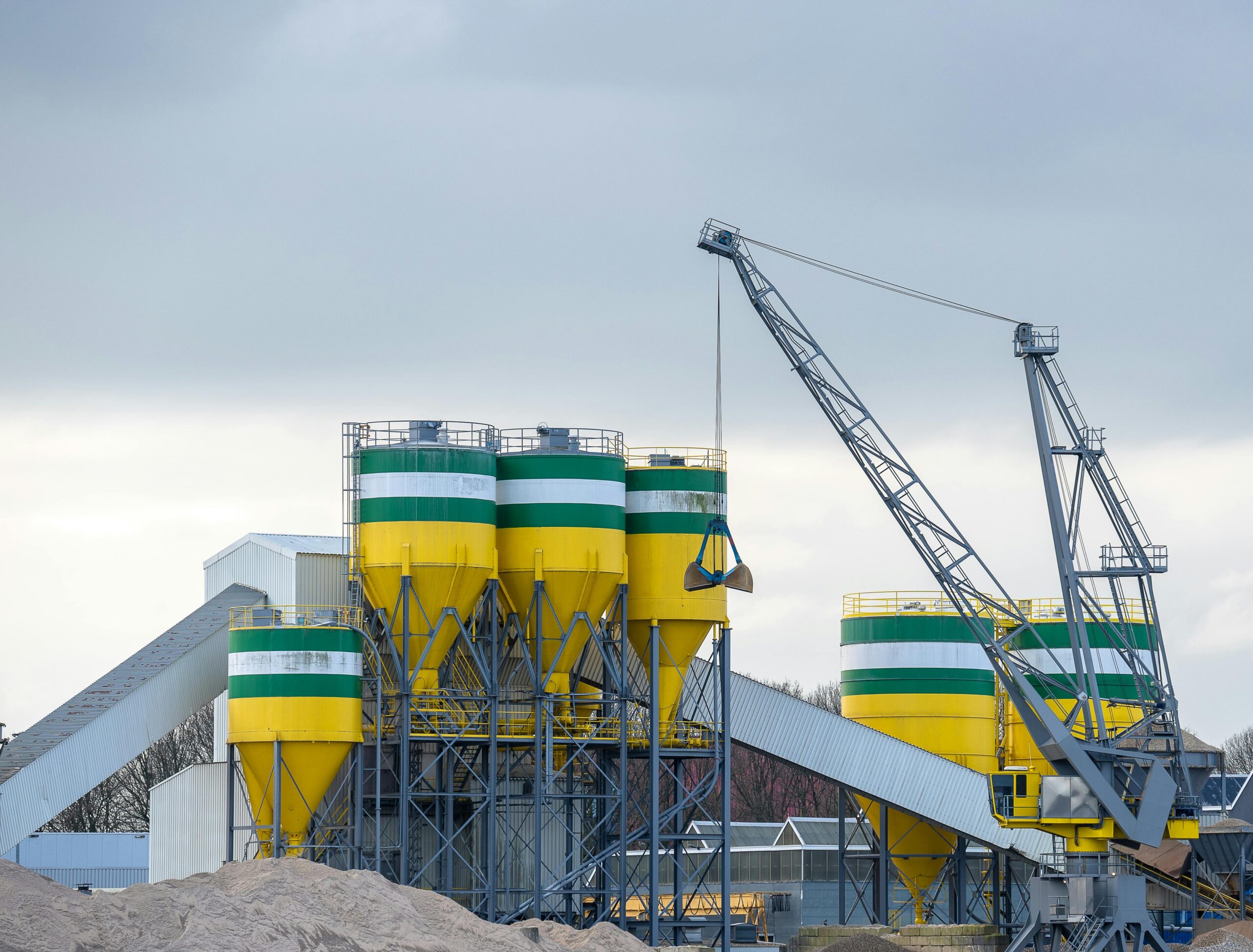 Cement silos and crane at a cement plant, illustrating industrial operations and equipment used in the cement industry.