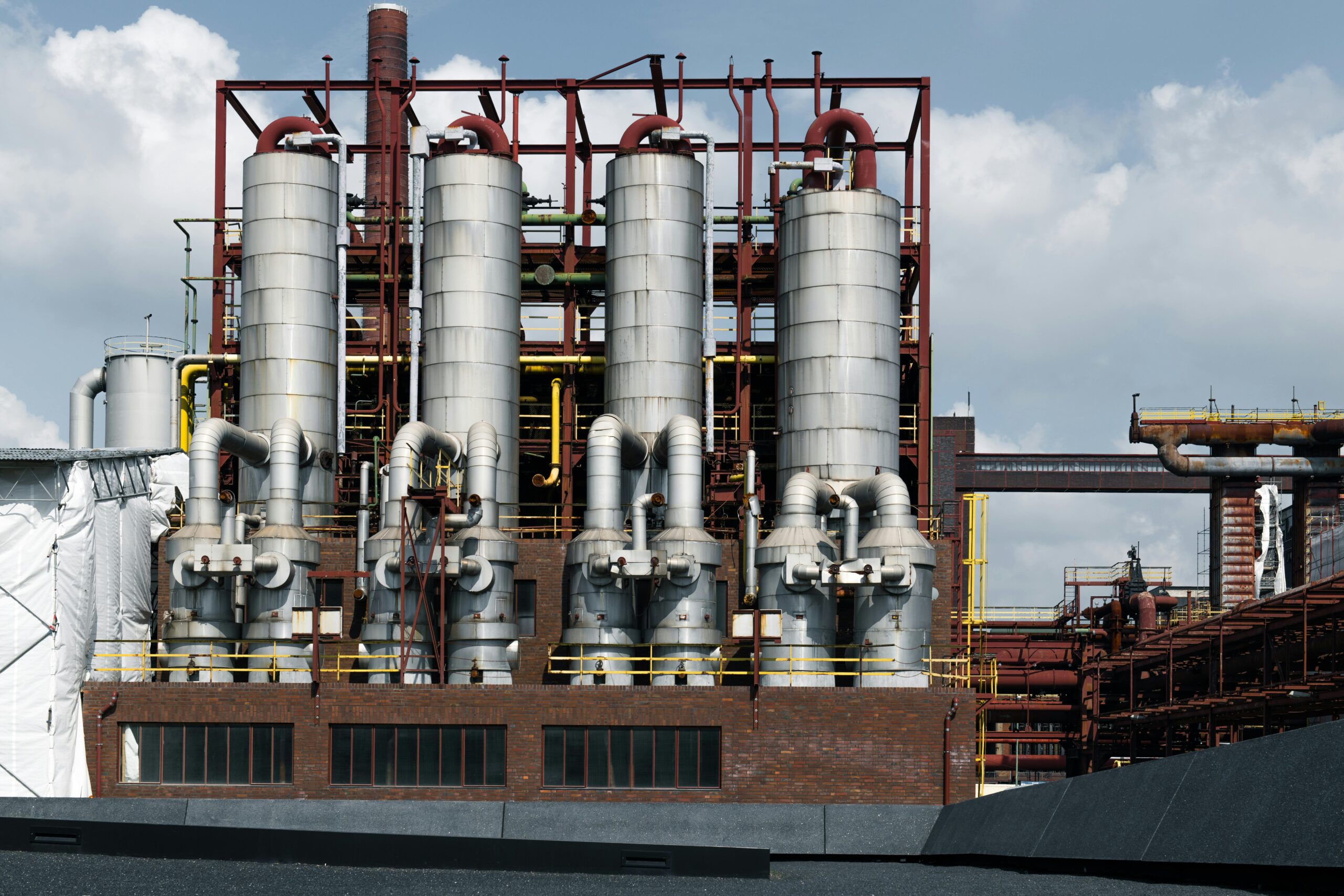 Industrial coal processing facility with large silos, pipes, and structural elements, showcasing infrastructure relevant to coal industry operations and maintenance services.