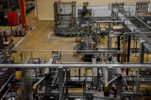 Interior view of a beer factory featuring numerous machines and equipment for industrial cleaning processes, relevant to Mid America Service Solutions' focus on maintaining operational efficiency in industrial facilities.